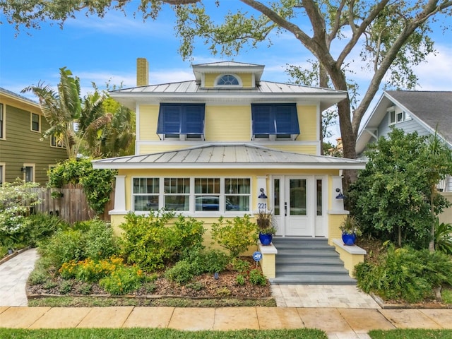 221 13th Ave NE, Saint Petersburg, FL 33701 - american foursquare style home featuring a standing seam roof, metal roof, fence, and a chimney