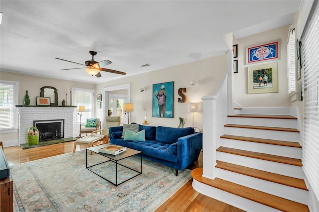 221 13th Ave NE, Saint Petersburg, FL 33701 - living room featuring wood finished floors, stairs, a brick fireplace, and a ceiling fan
