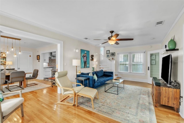 221 13th Ave NE, Saint Petersburg, FL 33701 - living room with stairway, ceiling fan, light wood-style floors, crown molding, and baseboards