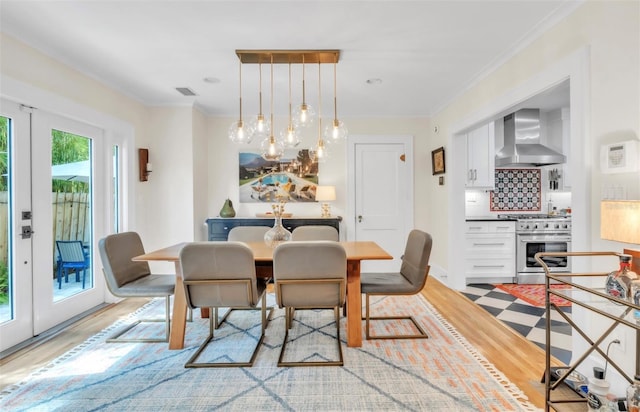 221 13th Ave NE, Saint Petersburg, FL 33701 - dining room featuring light wood-type flooring, a chandelier, crown molding, and french doors