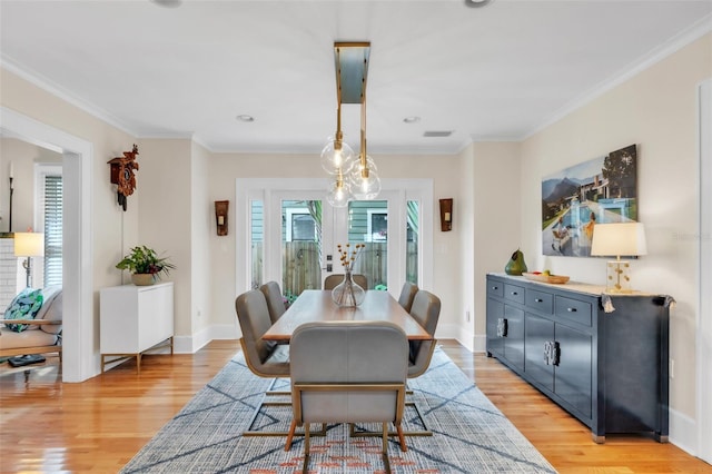 221 13th Ave NE, Saint Petersburg, FL 33701 - dining room with healthy amount of natural light, light wood-style flooring, crown molding, and baseboards