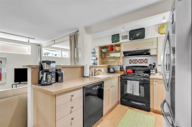221 13th Ave NE, Saint Petersburg, FL 33701 - kitchen featuring black appliances, extractor fan, light wood finished floors, light countertops, and a sink