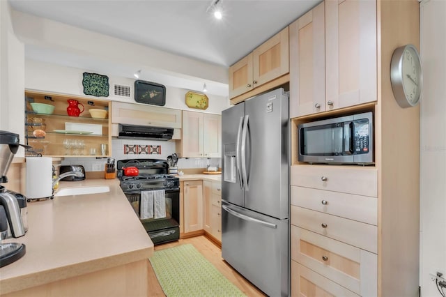 221 13th Ave NE, Saint Petersburg, FL 33701 - kitchen with stainless steel appliances, light brown cabinetry, extractor fan, and light countertops