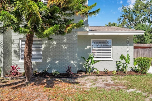 2078 Madrid Ct N, Clearwater, FL 33763 - view of side of property featuring brick siding, stucco siding, and fence