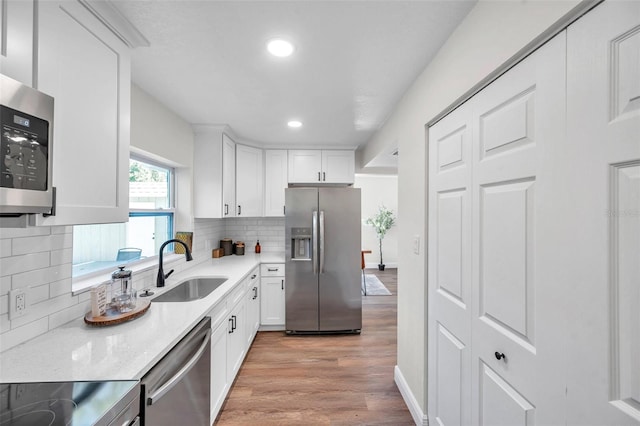 2078 Madrid Ct N, Clearwater, FL 33763 - kitchen with stainless steel appliances, a sink, decorative backsplash, recessed lighting, and light wood-style flooring