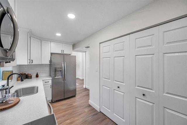 2078 Madrid Ct N, Clearwater, FL 33763 - kitchen with stainless steel fridge with ice dispenser, a sink, white cabinetry, light countertops, and recessed lighting