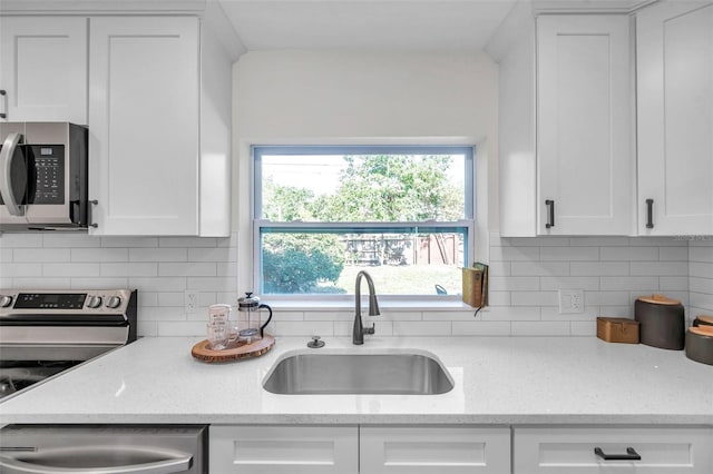 2078 Madrid Ct N, Clearwater, FL 33763 - kitchen with appliances with stainless steel finishes, a sink, white cabinets, and backsplash