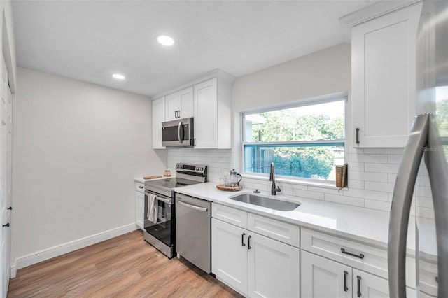 2078 Madrid Ct N, Clearwater, FL 33763 - kitchen featuring appliances with stainless steel finishes, a sink, light wood-type flooring, backsplash, and recessed lighting