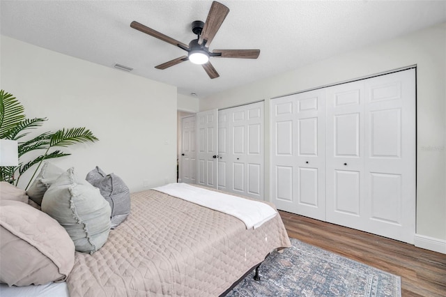 2078 Madrid Ct N, Clearwater, FL 33763 - bedroom featuring wood finished floors, two closets, a textured ceiling, and ceiling fan