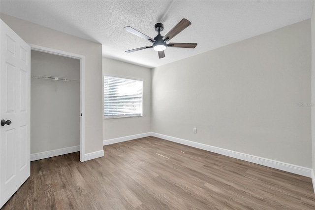 2078 Madrid Ct N, Clearwater, FL 33763 - unfurnished bedroom featuring wood finished floors, baseboards, a closet, a textured ceiling, and ceiling fan