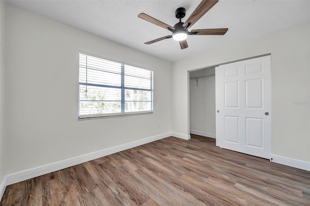 2078 Madrid Ct N, Clearwater, FL 33763 - unfurnished bedroom featuring wood finished floors, baseboards, a closet, and a ceiling fan
