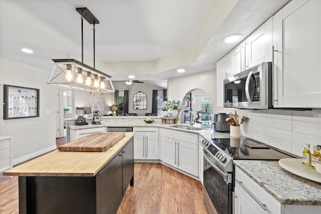 1914 Elk Spring Dr, Brandon, FL 33511 - kitchen featuring stainless steel appliances, wooden counters, a peninsula, a sink, and recessed lighting