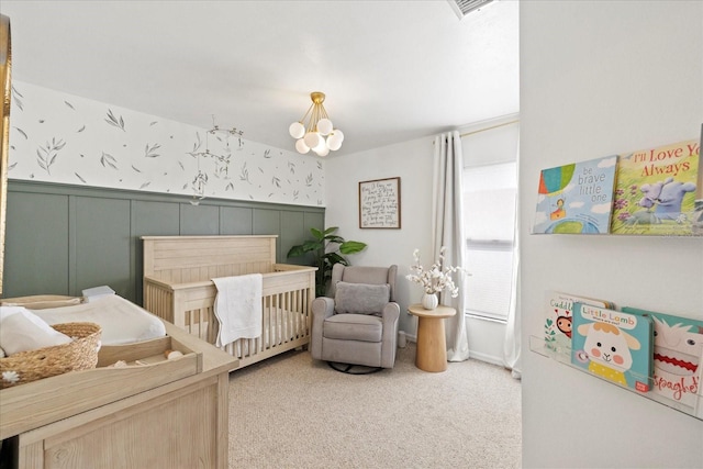 1914 Elk Spring Dr, Brandon, FL 33511 - carpeted bedroom featuring a crib, a wainscoted wall, and a chandelier