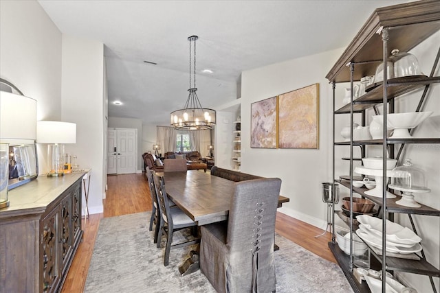 1914 Elk Spring Dr, Brandon, FL 33511 - dining space with light wood-type flooring, a chandelier, vaulted ceiling, and baseboards