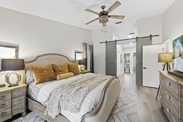 1914 Elk Spring Dr, Brandon, FL 33511 - bedroom featuring a barn door, light wood-style floors, a ceiling fan, and recessed lighting