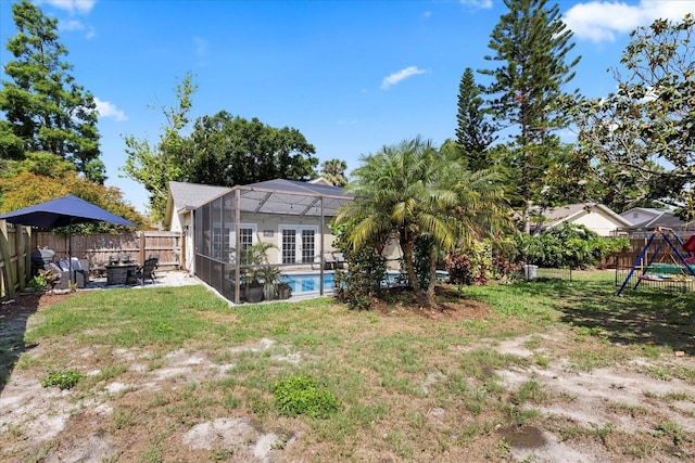 1914 Elk Spring Dr, Brandon, FL 33511 - rear view of house with a patio, glass enclosure, a playground, and an outdoor fire pit