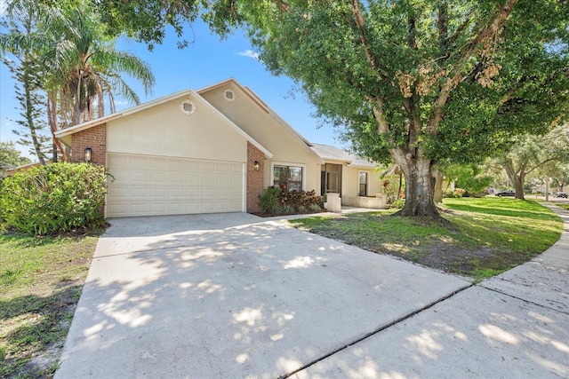 1914 Elk Spring Dr, Brandon, FL 33511 - view of front facade featuring brick siding, a garage, driveway, and stucco siding