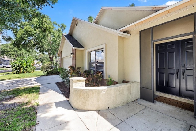 1914 Elk Spring Dr, Brandon, FL 33511 - doorway to property featuring an attached garage, stucco siding, and brick siding