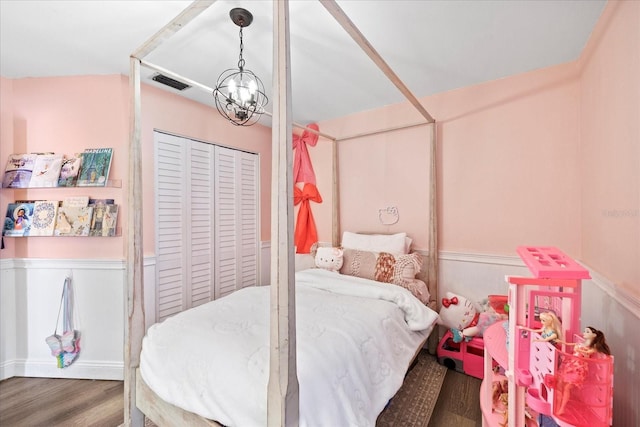 1914 Elk Spring Dr, Brandon, FL 33511 - bedroom featuring wainscoting, wood finished floors, a closet, and a chandelier