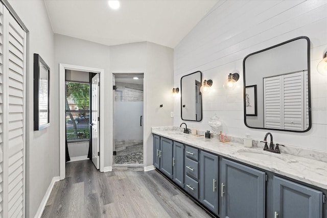 1914 Elk Spring Dr, Brandon, FL 33511 - full bath featuring wood finished floors, double vanity, a shower stall, baseboards, and vaulted ceiling