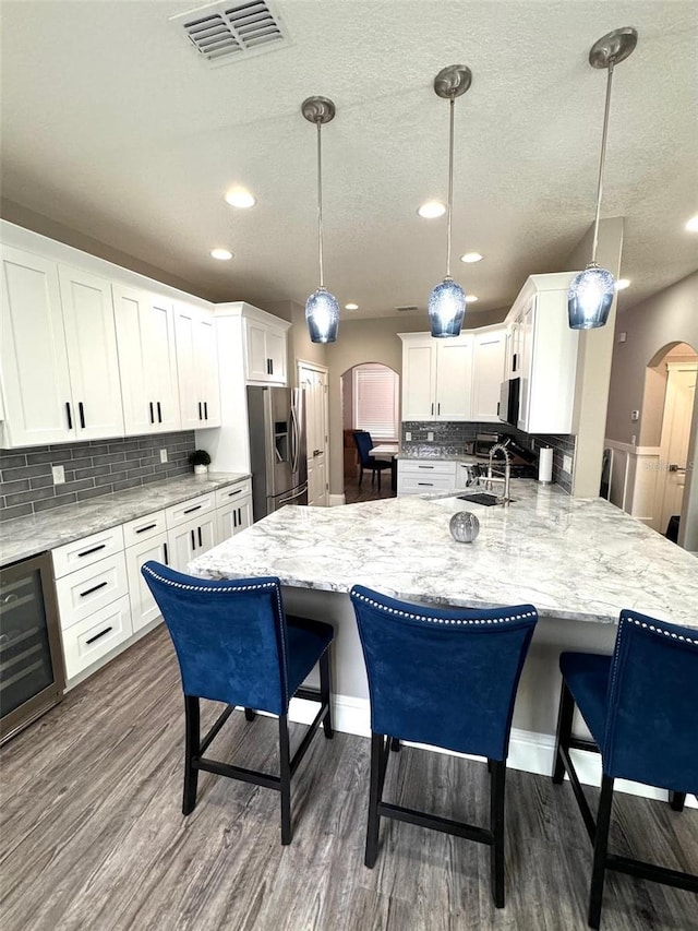 1147 Halapa Way, Trinity, FL 34655 - kitchen with stainless steel fridge with ice dispenser, arched walkways, wine cooler, a peninsula, and a sink