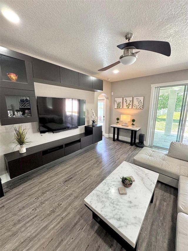 1147 Halapa Way, Trinity, FL 34655 - living area with arched walkways, ceiling fan, a textured ceiling, wood finished floors, and baseboards