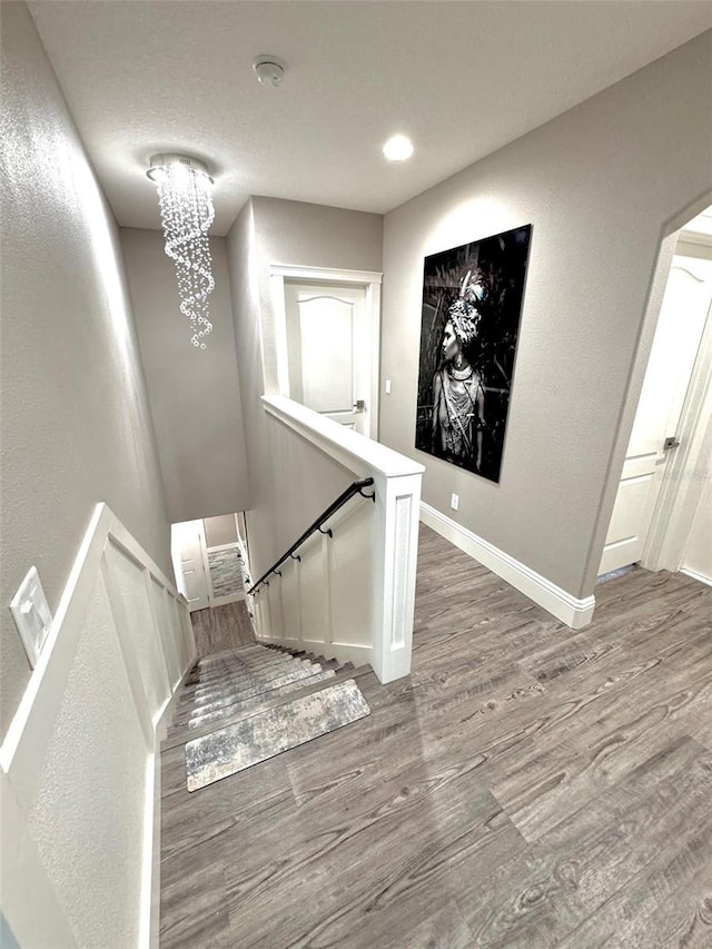 1147 Halapa Way, Trinity, FL 34655 - staircase with wood finished floors, a chandelier, baseboards, a textured wall, and recessed lighting