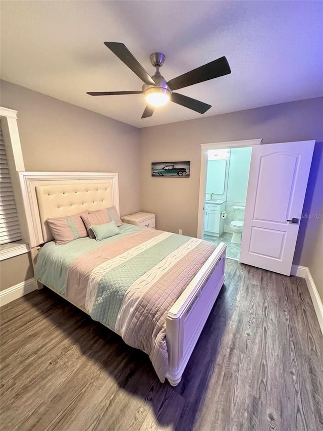 1147 Halapa Way, Trinity, FL 34655 - bedroom with dark wood-style floors, baseboards, ensuite bath, and ceiling fan