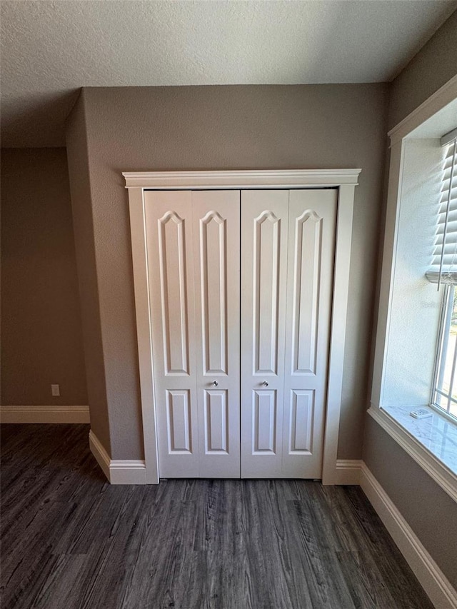 1147 Halapa Way, Trinity, FL 34655 - unfurnished bedroom with dark wood-style flooring, a closet, and baseboards