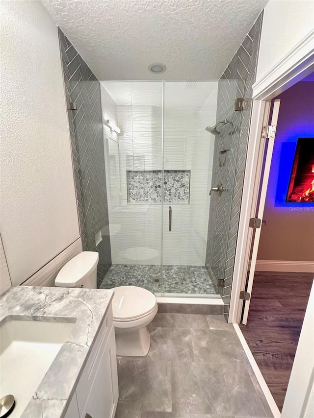 1147 Halapa Way, Trinity, FL 34655 - bathroom with toilet, a textured ceiling, vanity, a shower stall, and baseboards