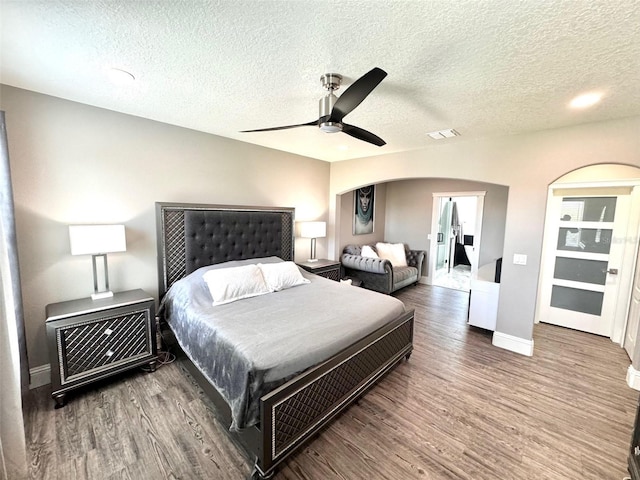 1147 Halapa Way, Trinity, FL 34655 - bedroom featuring wood finished floors, arched walkways, a textured ceiling, baseboards, and a ceiling fan