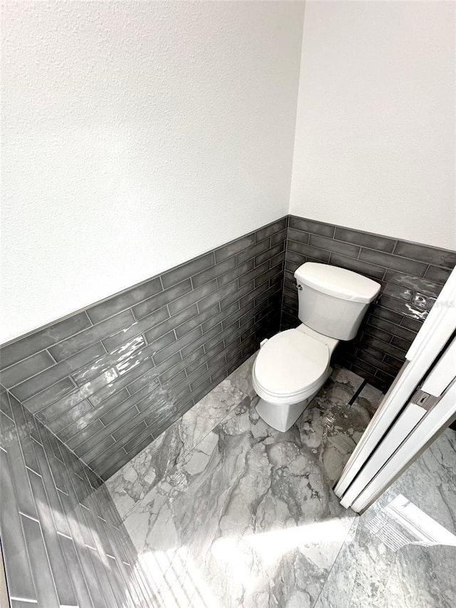 1147 Halapa Way, Trinity, FL 34655 - bathroom with tile walls, toilet, wainscoting, and marble finish flooring