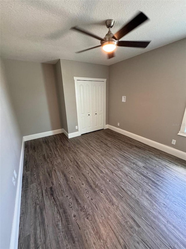 1147 Halapa Way, Trinity, FL 34655 - unfurnished bedroom with dark wood-style flooring, baseboards, a textured ceiling, a closet, and ceiling fan