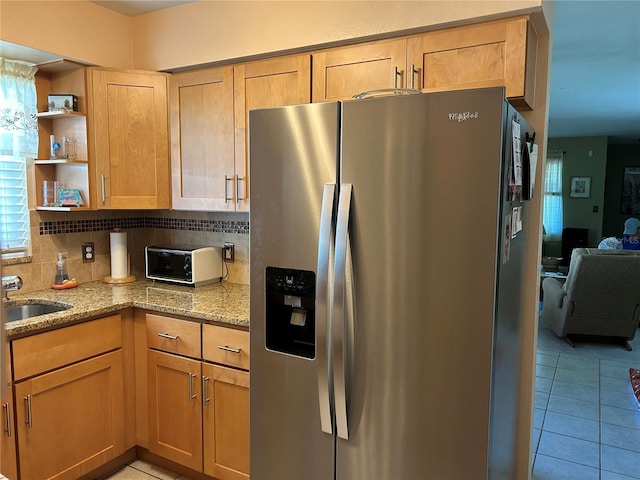 3827 15th Ave N, Saint Petersburg, FL 33713 - kitchen with stainless steel fridge, light stone countertops, light tile patterned floors, tasteful backsplash, and a sink