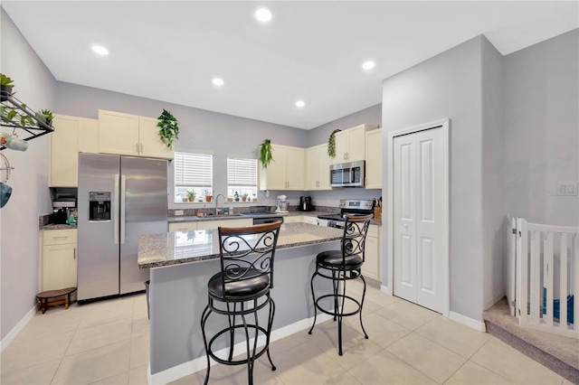 842 Tennyson Mill Cir, Tampa, FL 33619 - kitchen featuring stainless steel appliances, a sink, a breakfast bar area, a kitchen island, and light stone countertops