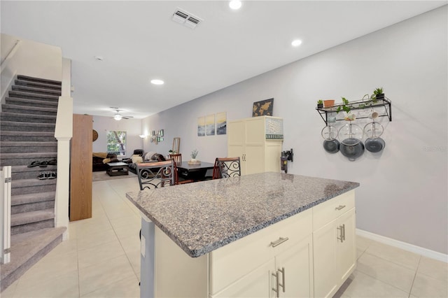 842 Tennyson Mill Cir, Tampa, FL 33619 - kitchen with dark stone countertops, light tile patterned floors, a ceiling fan, a center island, and recessed lighting