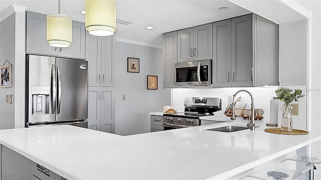 kitchen featuring stainless steel appliances, a sink, gray cabinets, light countertops, and ornamental molding