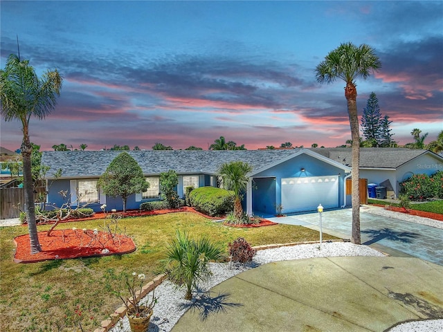 single story home with driveway, a garage, a front lawn, and stucco siding