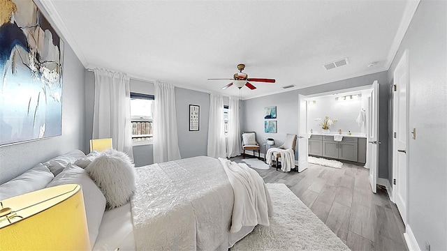 bedroom featuring light wood-style floors, crown molding, ceiling fan, and baseboards