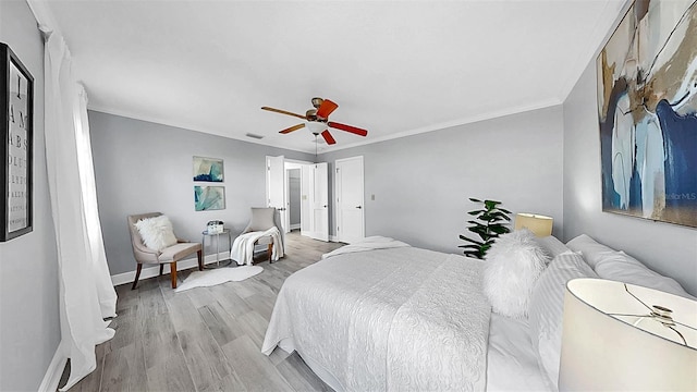 bedroom with wood finished floors, baseboards, a ceiling fan, and ornamental molding