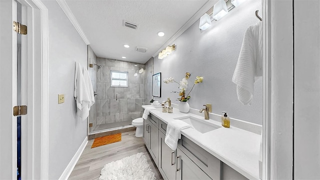 full bath with toilet, wood finished floors, a stall shower, vanity, and baseboards