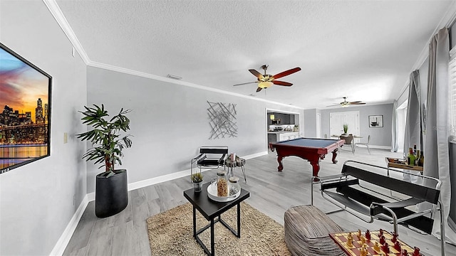 rec room with billiards, a textured ceiling, ceiling fan, wood finished floors, and ornamental molding