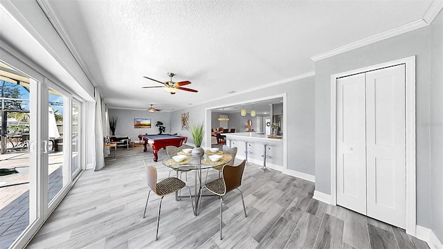 dining space with billiards table, light wood finished floors, a ceiling fan, crown molding, and baseboards