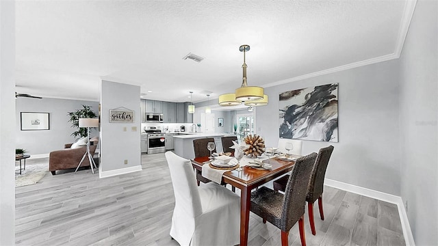 dining room featuring light wood-style flooring, baseboards, and ornamental molding