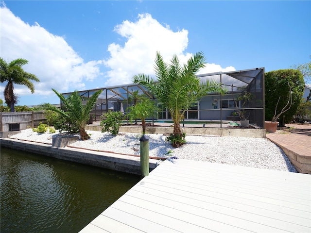 dock area with a water view, an outdoor pool, fence, and a lanai