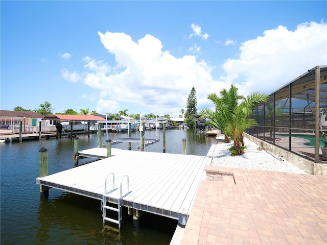 dock area featuring a water view, an outdoor pool, a lanai, and boat lift