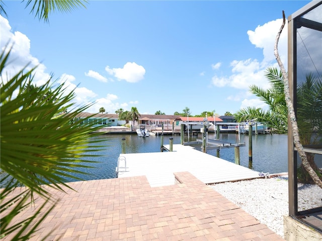 dock area featuring a water view, boat lift, and a residential view
