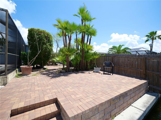 view of patio / terrace with fence and a lanai