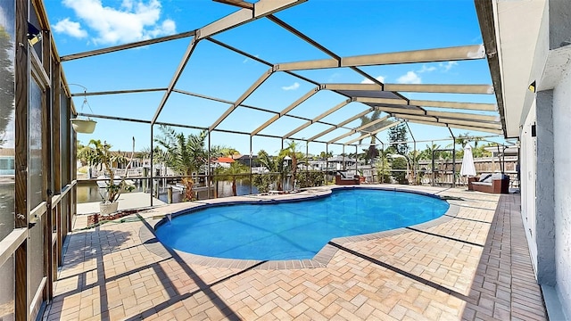 swimming pool featuring a patio area, a water view, and a lanai