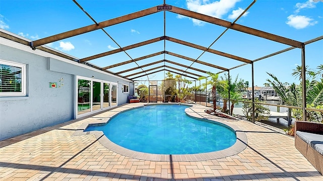 swimming pool with a patio area and glass enclosure